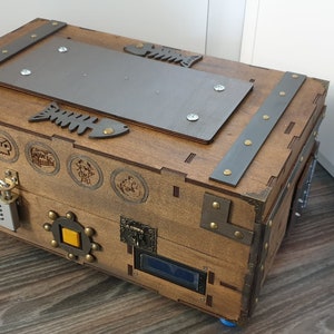 Puede incluir: Un cofre del tesoro de madera con detalles met&aacute;licos y una variedad de cerraduras y pestillos. El cofre est&aacute; decorado con un dise&ntilde;o de espina de pescado y otros s&iacute;mbolos.