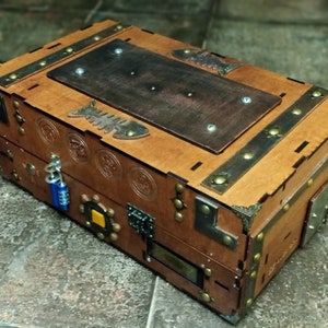 Puede incluir: Un cofre del tesoro de madera con una tapa marr&oacute;n, detalles met&aacute;licos y una cerradura de combinaci&oacute;n. El cofre tiene un dise&ntilde;o de espina de pescado y varios otros elementos decorativos.