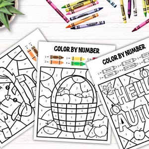 Puede incluir: Tres p&aacute;ginas para colorear imprimibles para colorear por n&uacute;meros con temas de oto&ntilde;o. La primera p&aacute;gina muestra un espantap&aacute;jaros, la segunda p&aacute;gina muestra una cesta de manzanas y la tercera p&aacute;gina muestra las palabras "Hello Autumn" con una calabaza y manzanas.