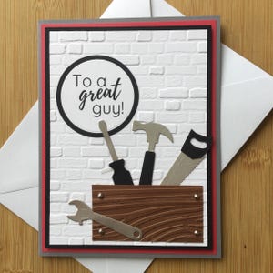 Carte faite main avec papier cartonné en couches gaufré et boîte à outils/outils avec l'inscription « To a Great Guy »