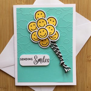 Carte de voeux faite main avec smileys ballons et gaufrage en nuage