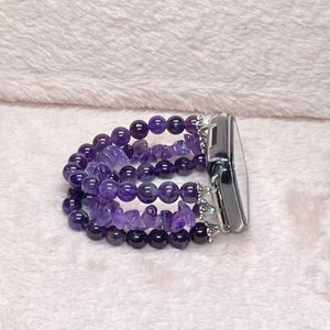 May include: A purple amethyst beaded watch band with silver accents. The band is made of multiple strands of beads and is designed to fit a smartwatch.