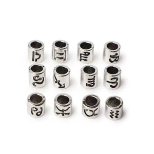 May include: Twelve silver-toned metal beads with zodiac symbols engraved on them. The symbols are: Libra, Gemini, Aquarius, Capricorn, Scorpio, Sagittarius, Virgo, Cancer, Leo, Taurus, Aries, and Pisces.