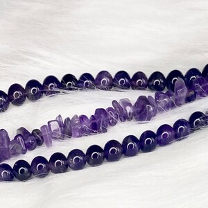 May include: A purple amethyst gemstone Apple Watch band with two rows of beads. The top row is made of small, irregular shaped beads and the bottom row is made of round beads.