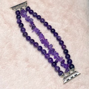 May include: A triple-strand amethyst watch band with a silver watch connector. The band is made of round and irregular shaped amethyst beads.