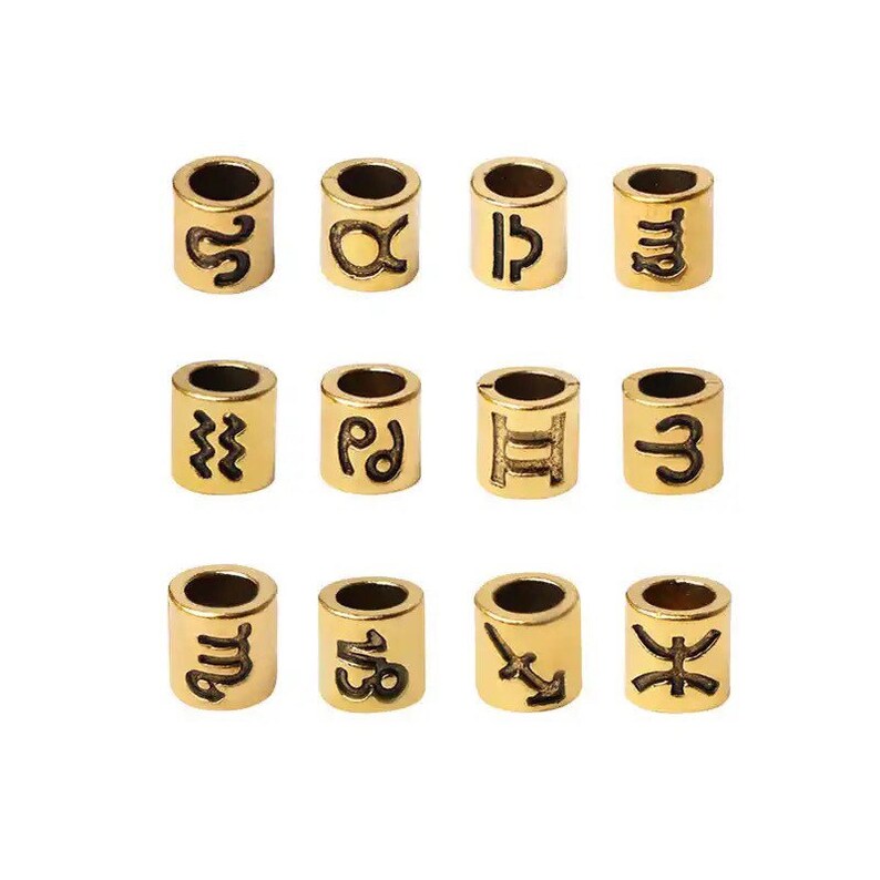 May include: Twelve gold-colored metal beads with different zodiac symbols engraved on them. The symbols include Aquarius, Aries, Cancer, Capricorn, Gemini, Leo, Libra, Pisces, Sagittarius, Scorpio, Taurus, and Virgo.