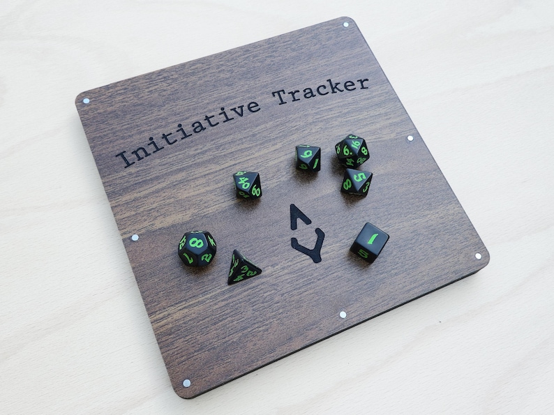 May include: A wooden Initiative Tracker board with the text "Initiative Tracker" in black. The board features a dark wood grain pattern and includes several dice with green numbers and markings. A black arrow symbol is also present.