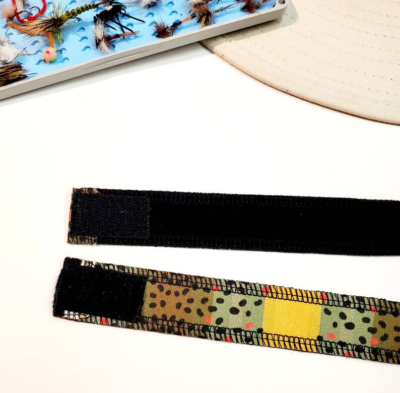 May include: Two black and brown patterned fabric bands with black velcro closures. The bands are designed to be worn around the wrist or arm.