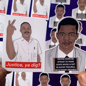 Puede incluir: Dos diseños de pegatinas con retratos de hombres afroamericanos. La primera pegatina presenta a un hombre con un signo de paz y el texto "Justice, ya dig?" La segunda pegatina presenta a un hombre con traje y el texto "Never, ever be afraid to make some noise & get in good trouble, necessary trouble."