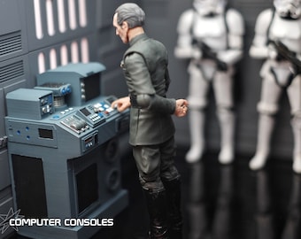 May include: A gray computer console with multiple buttons and screens, with a figure in a dark uniform operating it. Two white Stormtrooper figures stand in the background. The text "COMPUTER CONSOLES" is at the bottom.