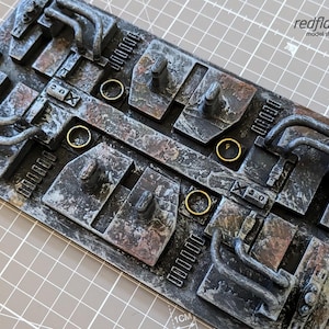 以下が含まれることがあります： スチームパンクな美学を持つ、風化した金属パネル。複数のレバー、パイプ、ギアが備わっており、さびた茶色と銀色の仕上げになっています。パネルは、傷や摩耗が目立つ、使い込まれたような外観をしています。