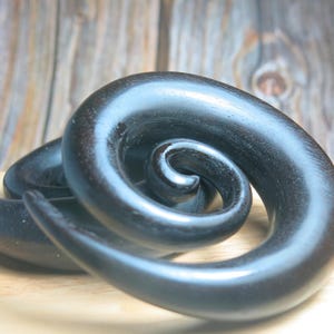 Calibri auricolari a spirale in legno nero: conicità organiche per piercing allungati