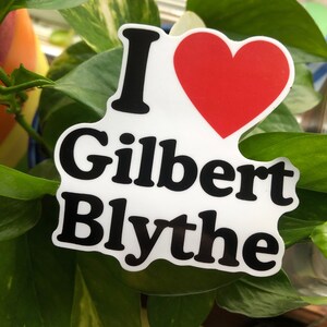 May include: White sticker with black text that reads "I love Gilbert Blythe" with a red heart in the middle.