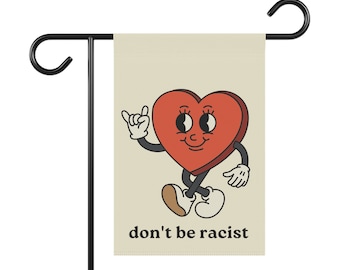 May include: A garden flag with a cartoon heart with eyes and a smile. The heart is wearing shoes and has its hand up in a 'hang loose' gesture. The text 'don't be racist' is printed below the heart.