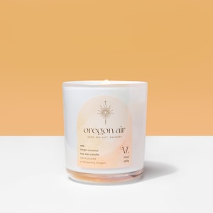 Peut inclure: Une bougie en verre blanc avec le texte "oregon air" et les ingrédients "sage, sea salt, oakmoss" imprimés sur une étiquette. La bougie est coulée à la main et fabriquée avec de la cire de soja vierge de noix de coco. Elle pèse 283g.