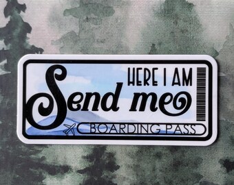 May include: A rectangular sticker with the words "Send me" in a stylized font, and "Here I Am" above "Boarding Pass". The background shows a blue sky and a mountain range, with a barcode on the right.
