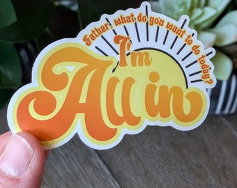 May include: A sticker with the phrase "I'm All In" in orange and yellow, in a retro font. The sticker also features the phrases "Father!" and "what do you want to do today?" with a sun graphic.
