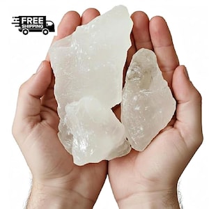 May include: Three translucent, irregularly shaped, light-colored mineral chunks are held in cupped hands. The image includes a small graphic of a truck with the words "FREE SHIPPING".