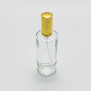 May include: A clear glass bottle with a gold spray top. The bottle is empty and ready to be filled with your favorite liquid.