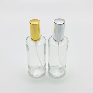 May include: Two clear glass spray bottles with gold and silver caps. The bottles are empty and ready to be filled with your favourite fragrance.