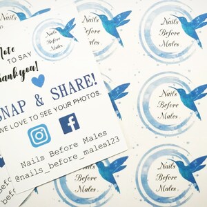 May include: White cards and stickers featuring blue hummingbird designs and text. The cards read "A little note to say Thank you!" and "Snap & Share!" with social media icons. The stickers display the text "Nails Before Males".