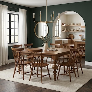 May include: A dining room set featuring a large wooden table with eight matching chairs. The chairs have a spindle back design. A gold chandelier hangs above the table, and a large mirror is on the wall. The room has a neutral rug and dark green walls.