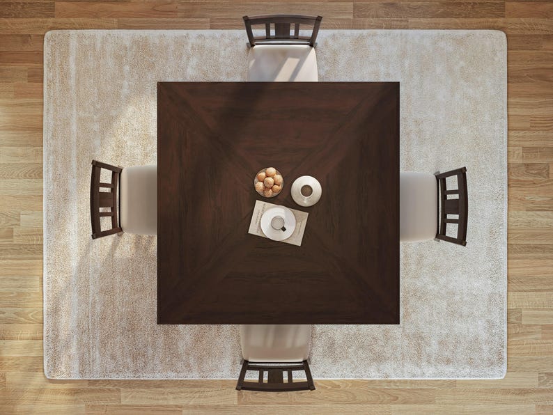 Puede incluir: Una mesa de comedor cuadrada de color marr&oacute;n oscuro con cuatro sillas. La mesa est&aacute; puesta con un cuenco de fruta, una taza y un platillo, y un objeto decorativo. La mesa est&aacute; sobre una alfombra blanca.