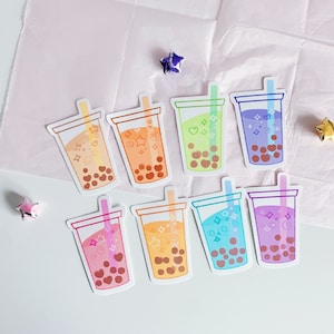 May include: Eight colorful bubble tea stickers with different designs and colors. The stickers are on a pink and white background.
