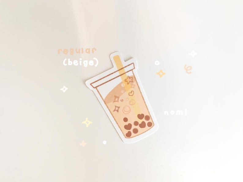 May include: A beige sticker with a cartoon illustration of a boba tea cup with brown boba pearls, a straw, and hearts and stars inside. The text "regular (beige)" and "nom!" are also on the sticker.