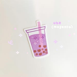 May include: A sticker of a purple ube milk tea with boba pearls and a pink straw. The text "ube (magenta)" is written above the drink.