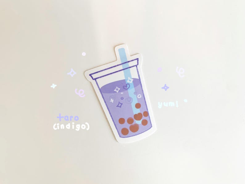 May include: A sticker of a purple taro milk tea with boba pearls and a straw. The sticker has a white background with purple and white stars and the text "taro (indigo)" and "yummy".