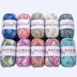 May include: Ten skeins of multi-coloured yarn, each with a label bearing Chinese characters. The yarn displays a mix of blue, pink, green, yellow, and grey hues in a variegated pattern. Suitable for knitting and crochet projects.
