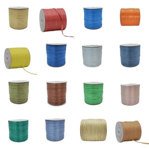 Puede incluir: Dieciséis carretes de cinta plana en varios colores, incluyendo amarillo, rojo, azul, naranja, verde, marrón, gris y beige. Cada carrete es cilíndrico con un núcleo central, enrollado cuidadosamente con cinta fina y lisa para manualidades.