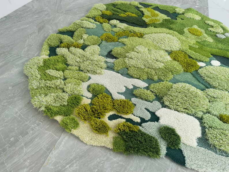 May include: A green, blue, and white rug with a textured, abstract design. The rug is made of soft, fluffy fibers and has a unique, organic look.