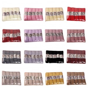 May include: A collection of sixteen individual packs of yarn, each containing five skeins wrapped in clear plastic. The yarn colors include white, pink, cream, red, dark red, light purple, mauve, dusty rose, gray, lavender, black, maroon, beige, tan, yellow, and brown.