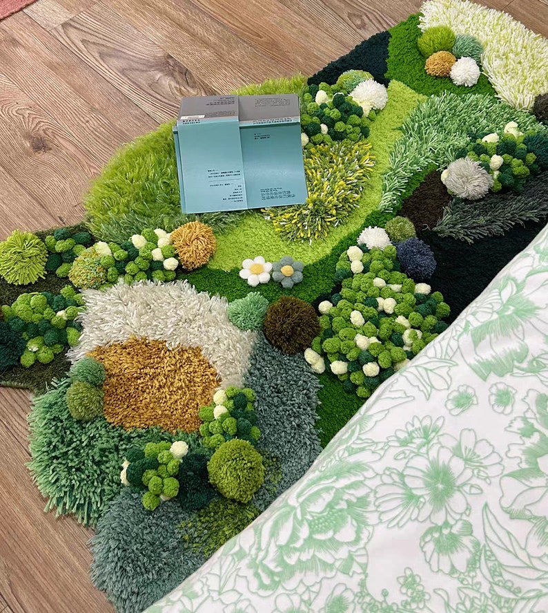 May include: A green, white, and yellow rug with a textured, fluffy surface. The rug is shaped like a cloud and has a variety of different textures and colors. The rug is made of yarn and has a variety of different shapes and sizes. The rug is perfect for adding a touch of whimsy to any room.