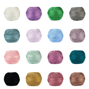 Op de afbeelding: Een raster van twaalf bollen garen in verschillende kleuren, waaronder wit, paars, groen, grijs, blauwgroen, lichtroze, blauw en bruin. Het garen is strak opgerold en elke bol heeft een consistente grootte en vorm, geschikt voor brei- of haakprojecten.