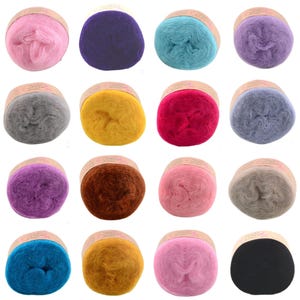 Peut inclure: Une collection de seize pelotes de laine individuelles disposées en une grille de quatre par quatre. Chaque pelote présente une texture duveteuse et douce, entourée d'une bande de papier beige. Les couleurs incluent rose, violet, turquoise, lavande, gris, jaune, rouge, bleu, marron et noir.