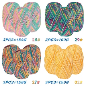 May include: Four sets of yarn skeins in various colours. Each set contains three skeins. The yarn colours include pink, green, yellow, blue, and orange. The text on the image reads "3PCS=150G" and numbers 26, 29, 27, and 02.