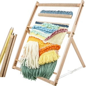 Op de afbeelding: Een houten weefgetouw met een kleurrijk geweven wandtapijt. Het wandtapijt heeft verschillende texturen en kleuren, waaronder blauw, geel, oranje en groen. Het weefgetouw is schuin geplaatst en heeft een apart houten stuk met gele draden.