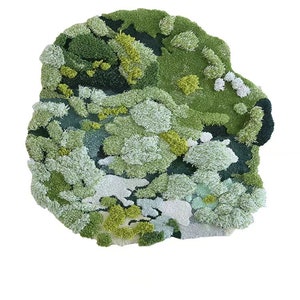 May include: A green, white, and yellow abstract rug with a textured, fluffy surface. The rug is shaped like a cloud and has a variety of different textures.