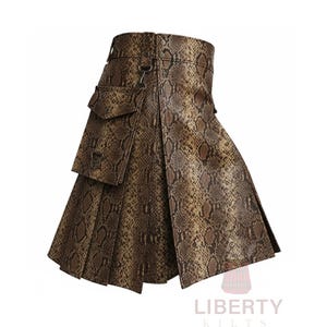 Pode incluir: Um kilt marrom e bege com padrão de pele de cobra e design plissado. O kilt apresenta um bolso na frente e um fecho de metal. O canto inferior direito da imagem mostra o texto "LIBERTY KILTS".