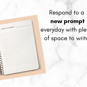 May include: A white spiral bound notebook with a light blue sticky note on the cover. The notebook has lined pages and the text "TODAY'S PROMPT:" is printed on the cover. The notebook is on a light peach background.