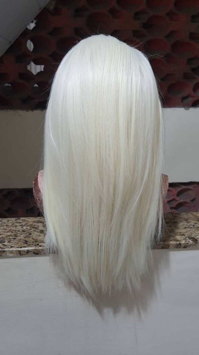 Puede incluir: Una peluca larga, recta, de color rubio platino con un corte recto.