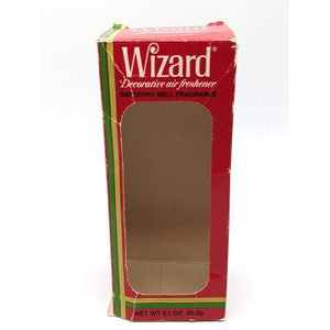 May include: Red and green cardboard box with a clear window. The box is for a Wizard brand decorative air freshener with a bayberry bell fragrance. The box says "Net Wt 2.1 oz 59.5g".