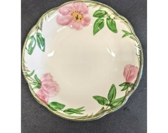 May include: A white ceramic bowl with a scalloped edge and a floral design featuring pink roses and green leaves.