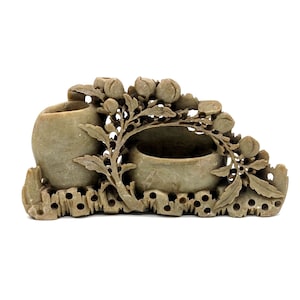 May include: A carved green stone sculpture of a tree with two small vases and a bowl. The sculpture is intricately detailed with leaves and flowers.