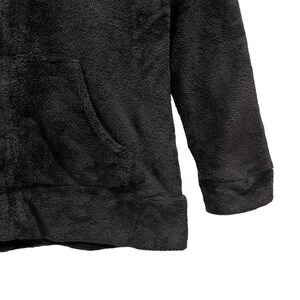 Peut inclure: Un sweat &agrave; capuche noir en polaire avec une poche kangourou.