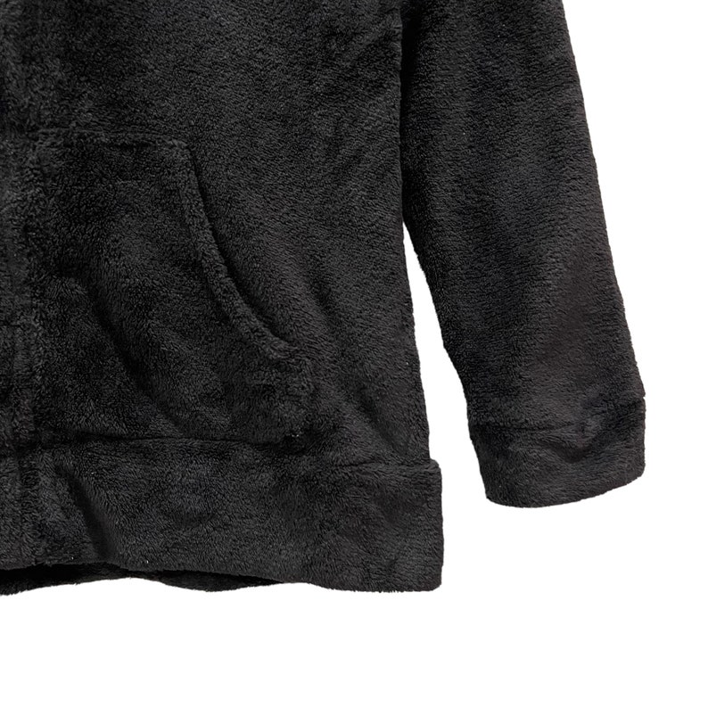Peut inclure: Un sweat &agrave; capuche noir en polaire avec une poche kangourou.