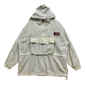 May include: A white hooded anorak jacket with a large front pocket and a small patch with the text "All Terrain" on the upper right side.